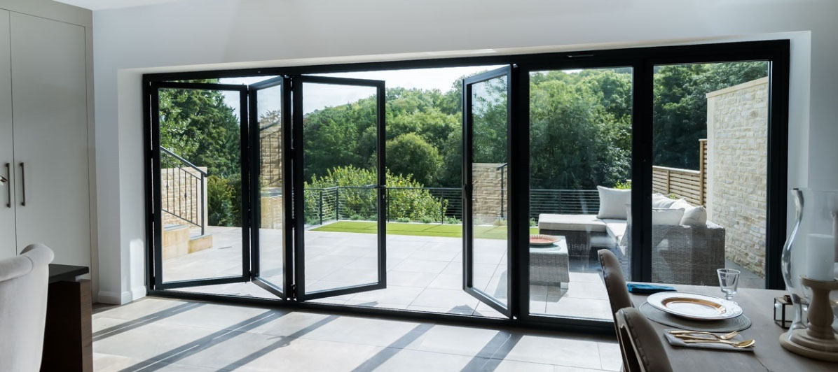 Aluminum bifold door frame and panels being installed in a large opening